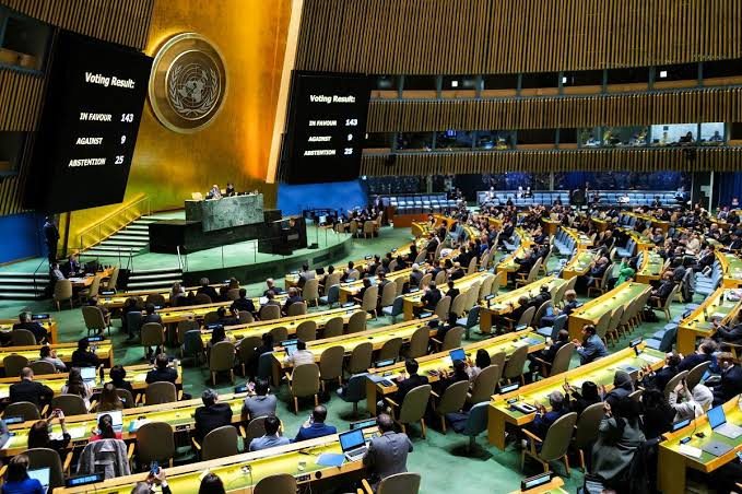 The United Nations General Assembly hall during a recorded vote, with the voting result displayed on the screens.